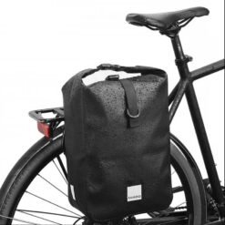 Sacoche de vélo noire 10L étanche installée sur porte-bagage arrière et portée en bandoulière